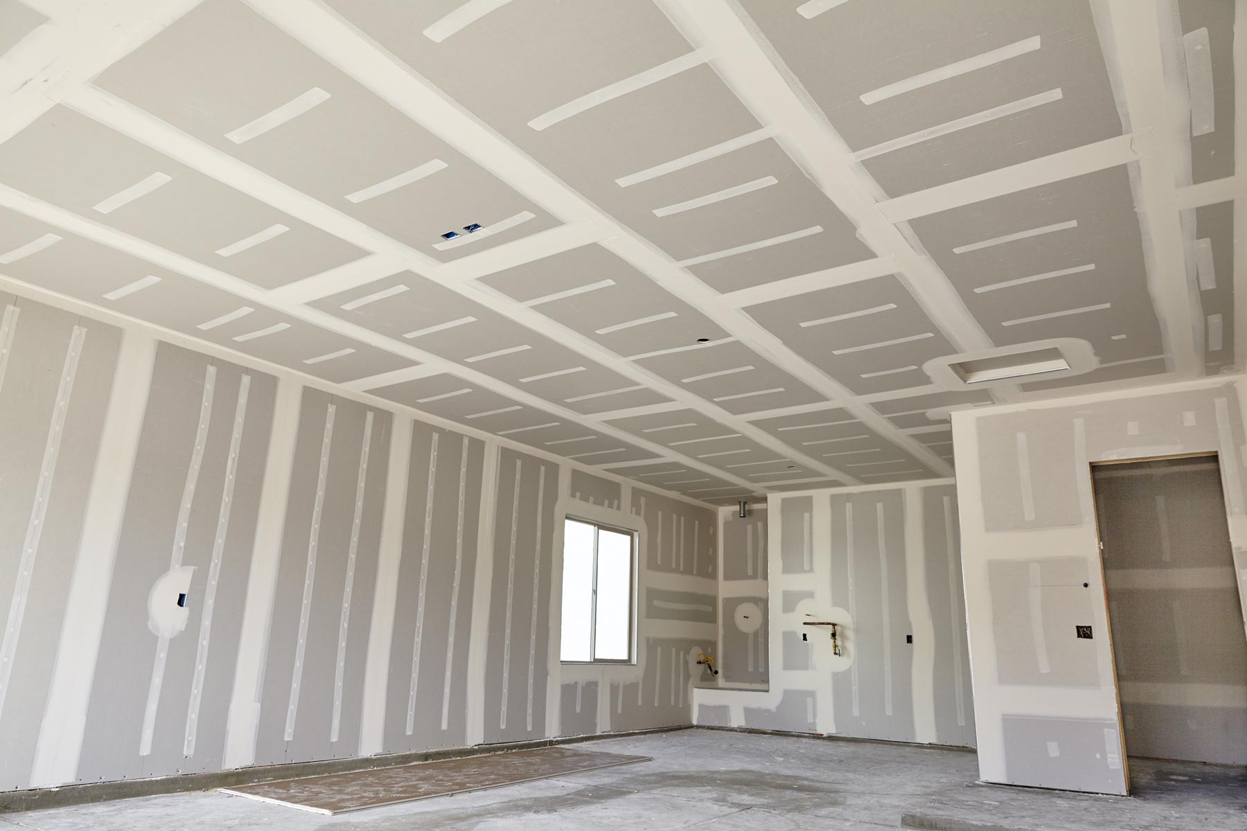 Drywall installed on walls and ceilings, ready for finishing